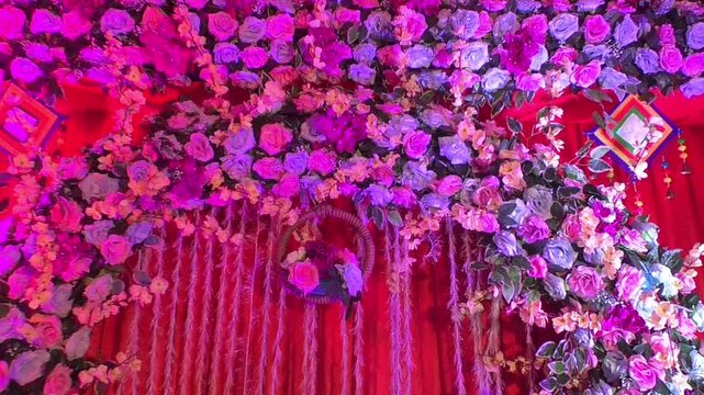 Beautiful wedding decoration featuring colorful artificial and fresh flowers, marigold garlands, floral arches, decorative lights, wedding backdrop elements, and festive stage arrangements.