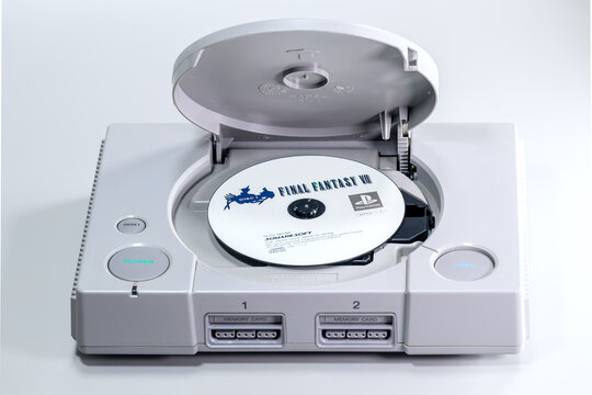 Fukuoka, Japan. June 6, 2026: Original Sony PlayStation console with the disc lid open and a Final Fantasy VII game disc inside the CD-ROM drive.