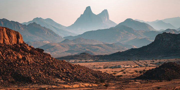 Rocky Desert Landscape with Distant Mountain Silhouettes