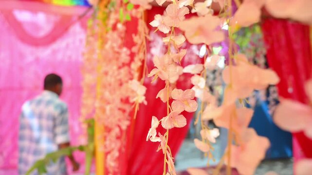 Luxury Wedding Venue Decoration with Colorful Flower Arrangements, The decorative wedding backdrop features flowers, lights, floral arches, and festive stage elements used during marriage celebrations