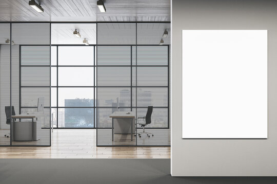 Modern office interior featuring a large blank vertical poster mockup mounted on a clean wall beside glass-partitioned workspace in a contemporary business setting. 3D Rendering