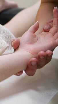 Spa. A massage therapist is working with a young woman - Vertical video