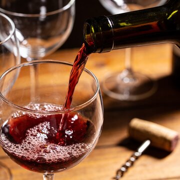 Red wine is poured from a bottle into a glass.
