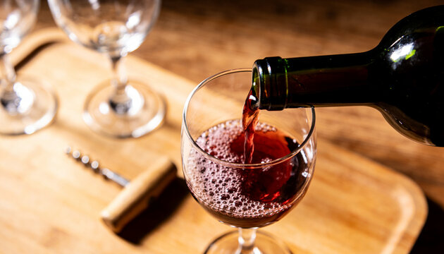 Red wine is poured from a bottle into a glass.