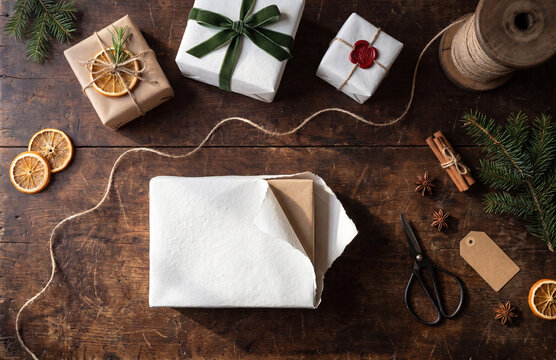 Christmas gift wrapping supplies on rustic wooden table with copy space