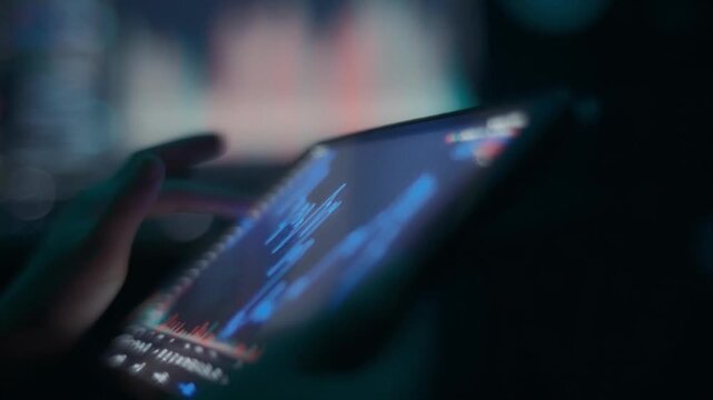 trader investor using tablet for stock market monitoring with candlestick chart. Trading app with crypto graphs on screen. tech laptop computer Smartphone mobile phone. Bitcoin Data Financial analysis