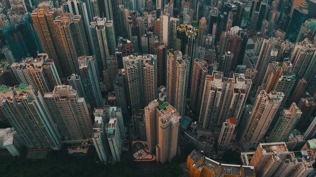 Aerial view of dense urban cityscape with towering skyscrapers at sunset.