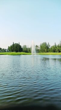 Serene Lake Fountain Green Park Landscape Under Clear Blue Sky. Beautiful freshwater lake with a fountain surrounded by green trees and grass under a clear blue sky
Tangerang, Banten, Indonesia. 