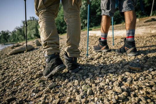 Close up of trekking shoes on riverside hiking path
