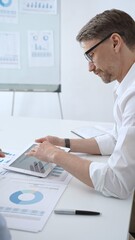 Obraz premium Business professional leading meeting, analyzing financial data and marketing reports on tablet during corporate presentation, discussing strategy with colleagues