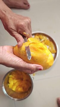 Peeling Ripe Mango Skin with Knife to Make Mango Pulp