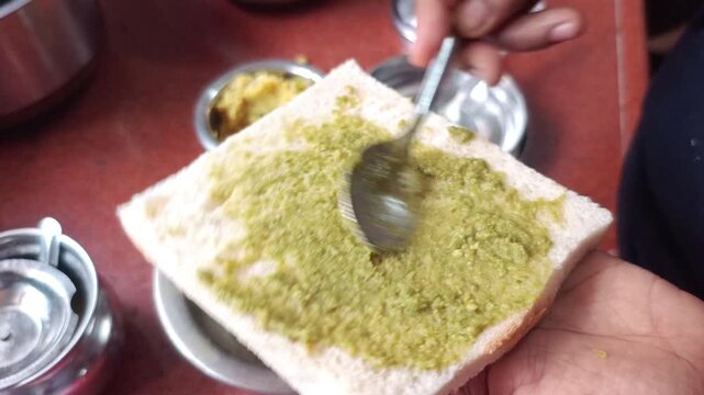 Spreading Green Mint Chutney on White Bread Slice for Sandwich Making 