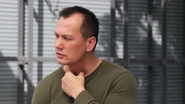 Middle aged Asian man having sore throat and catching a cold or flu, man suffering from sickness