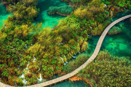 Aerial top down view of a wooden walkway in Plitvice Lakes National Park with small waterfalls