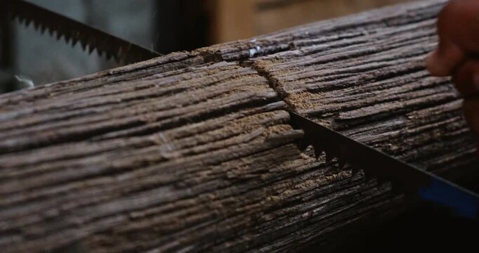 close up, cutting and sawing wooden log for constructing, cabin building or support beam.. High quality 4k footage