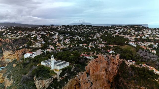 Aerial wide shot of Cap de la Nau cliffs and lighthouse, Costa Blanca, Spain