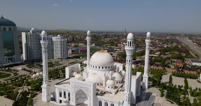Epic aerial push-in shot of the magnificent white marble Pride of Muslims mosque and cityscape in Shali, Chechnya