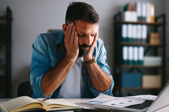 Stressed businessman suffering from headache and occupational burnout