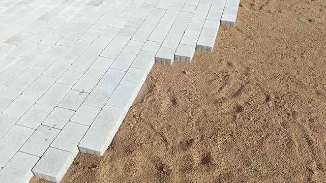 The process of laying paving slabs. Construction of roads in a park, city