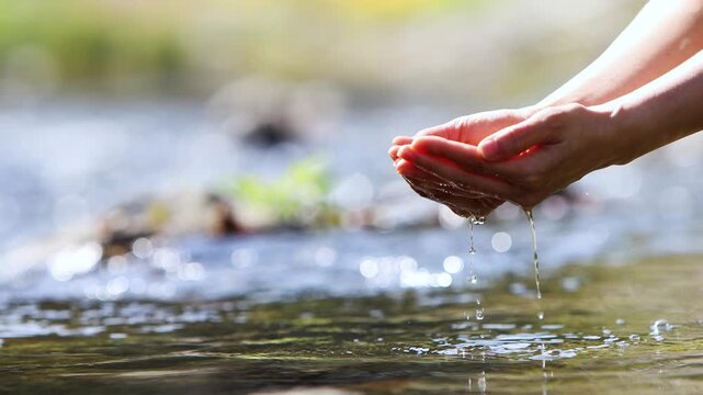 Holding clear, clean, and cool valley water in your hands, a background of precious life-giving water and World Water Day concept