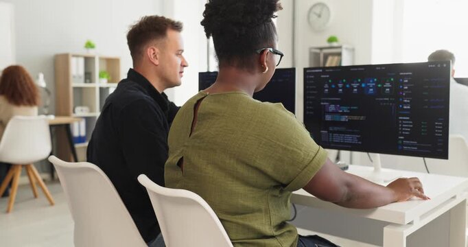 Developers and programmers conduct code review collaboration. They analyze code on a computer screen in a bright office, improving workflow. Concept focuses on teamwork and technology.