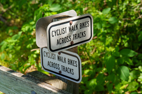Cyclists are asked to walk bikes across the tracks in a green area