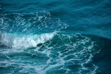Naklejka premium Turbulent teal ocean waves with white foam