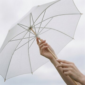 Woman holding transparent umbrella on windy day outside