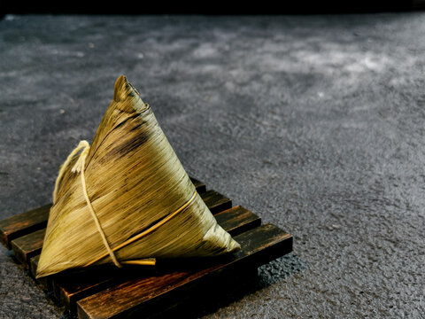 Bacang is a traditional Chinese food wrapped in bamboo leaves in a triangular pyramid shape filled with glutinous rice with soy sauce pork or chicken, salted egg, and sometimes mushrooms or peanuts.