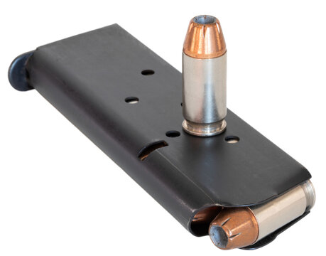 45 caliber cartridge with copper plated bullet on a pistol managine