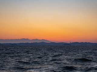 Fototapeta premium 黄金色に染まる夕焼け空と波立つ冬の海