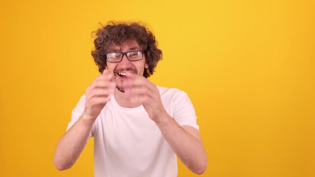 Cheerful young person laughing and smiling while looking at the camera in a bright yellow studio portrait, conveying joy, fun and a lighthearted comedy‑watching mood.
