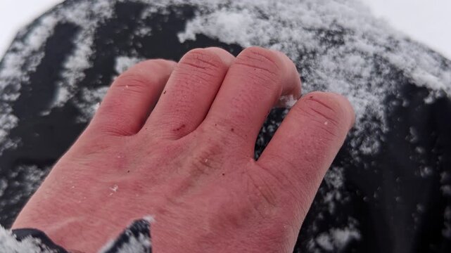 Bare hands red from freezing cold in deep winter snow