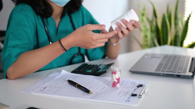 A female doctor in a hospital room holding a medicine bottle, wearing a medical uniform, holding a medicine bottle while explaining to a patient the dosage and usage.