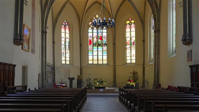 Empty nave inside Eglise Saint Maurice with wooden pews and Gothic vaults