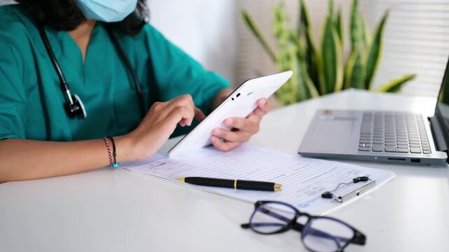 Doctors scroll and type on smartphones in hospitals for research, communication, or healthcare news. They use smartphones and type in clinics for electronic medical records and mobile health apps.