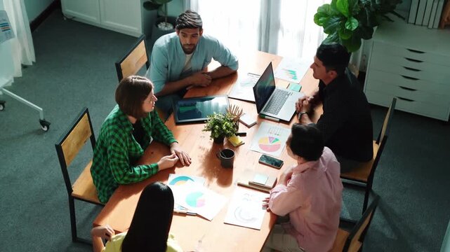 Top view of caucasian businessman present marketing plan by show financial graph to diverse investor to make decision for investment. Diverse business people discussion about smart plan. Convocation.