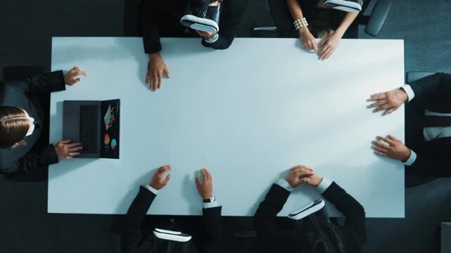 Top down aerial view of professional business team wear vr headset to enter virtual world while sitting and using hand gestures to manipulate the data from the manager laptop. Technology. Directorate.