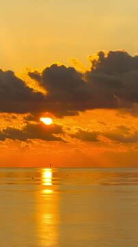 Time lapse of the sun rising through the clouds at dawn in Key West Florida. Vertical Video.