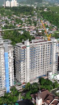 Aerial shot of the poor neighborhoods mixed in with new modern high-rises in Cebu City Philippines. Vertical Video.