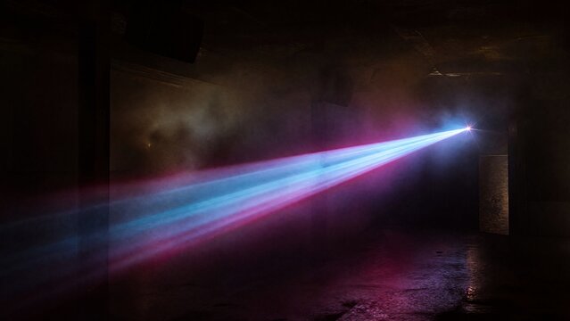 Dark underground club with single colorful laser beam through haze.