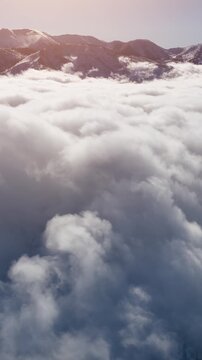 Aerial of clouds and fresh snow covering the San Bernardino Mountains near Los Angeles California. Vertical video.