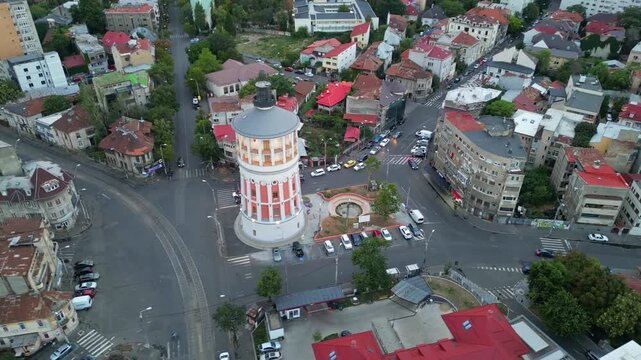 High angle daytime view of the historic Bucharest fire tower in Romania. Beautiful old circular brick architecture surrounded by urban city streets.