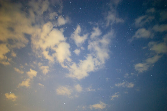 Starry Night Sky with Glowing Clouds and Deep Blue Atmosphere