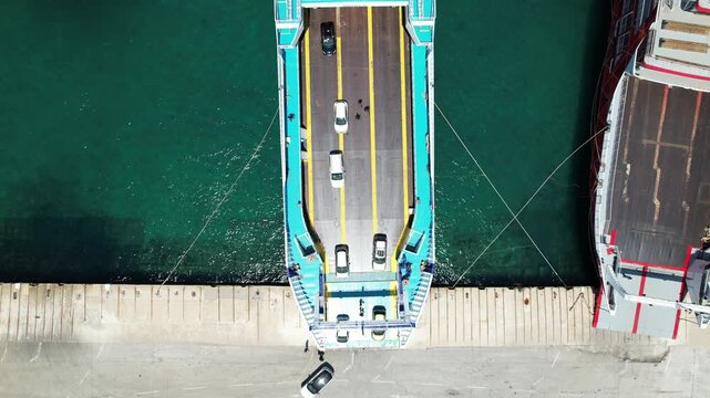 Aerial top down view of cars boarding a ferry boat