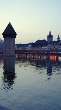 Vertical static shot of the historic Chapel Bridge and Reuss river at dusk