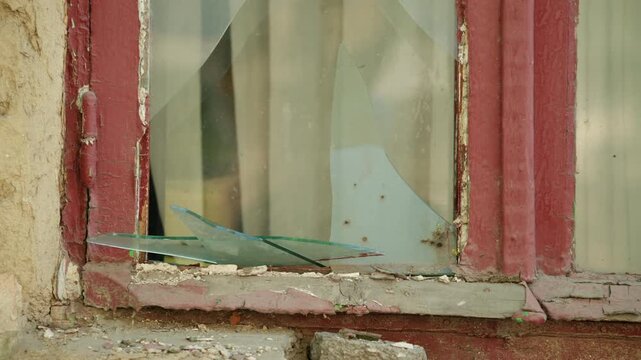 Close up view of a damaged window with shattered glass in an old building