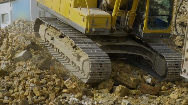 Crawler excavator rolling down a hill at a construction site
