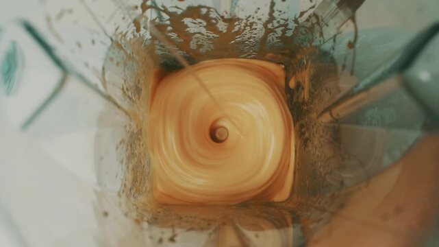 mixing homemade mayonnaise ingredients and adding water inside kitchen mixer.