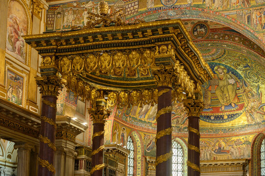 Interior view of the Basilica of Saint Mary Major in Rome, Italy. The magnificent baldacchino altar canopy with porphyry columns, showcasing the medieval golden apse mosaic in the background